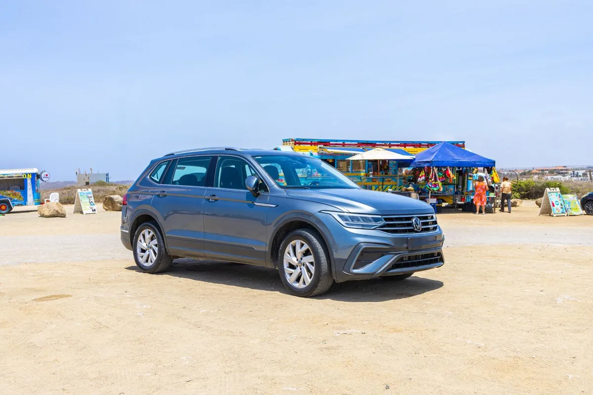 A rental SUV parked by a colourful market stall in Aruba
